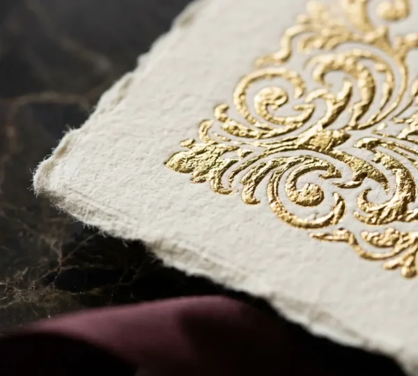 Gros plan sur une invitation luxueuse avec détails dorés et texture de papier épais visible
