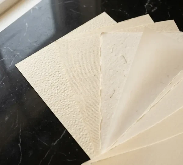 Différentes textures de papiers de création haut de gamme disposés en éventail sur une surface en marbre